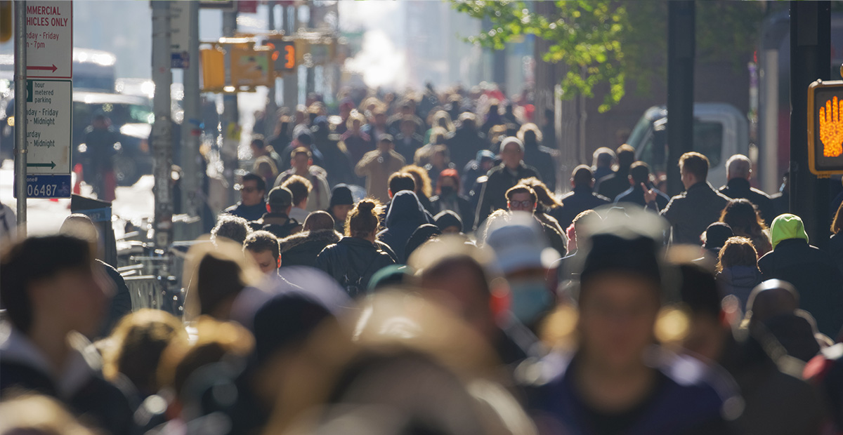 A crowd of people walking on a busy city street