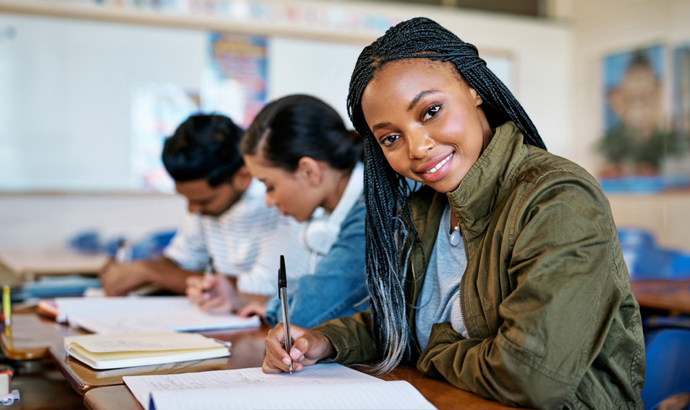 Young college student sitting at a desk in a classroom